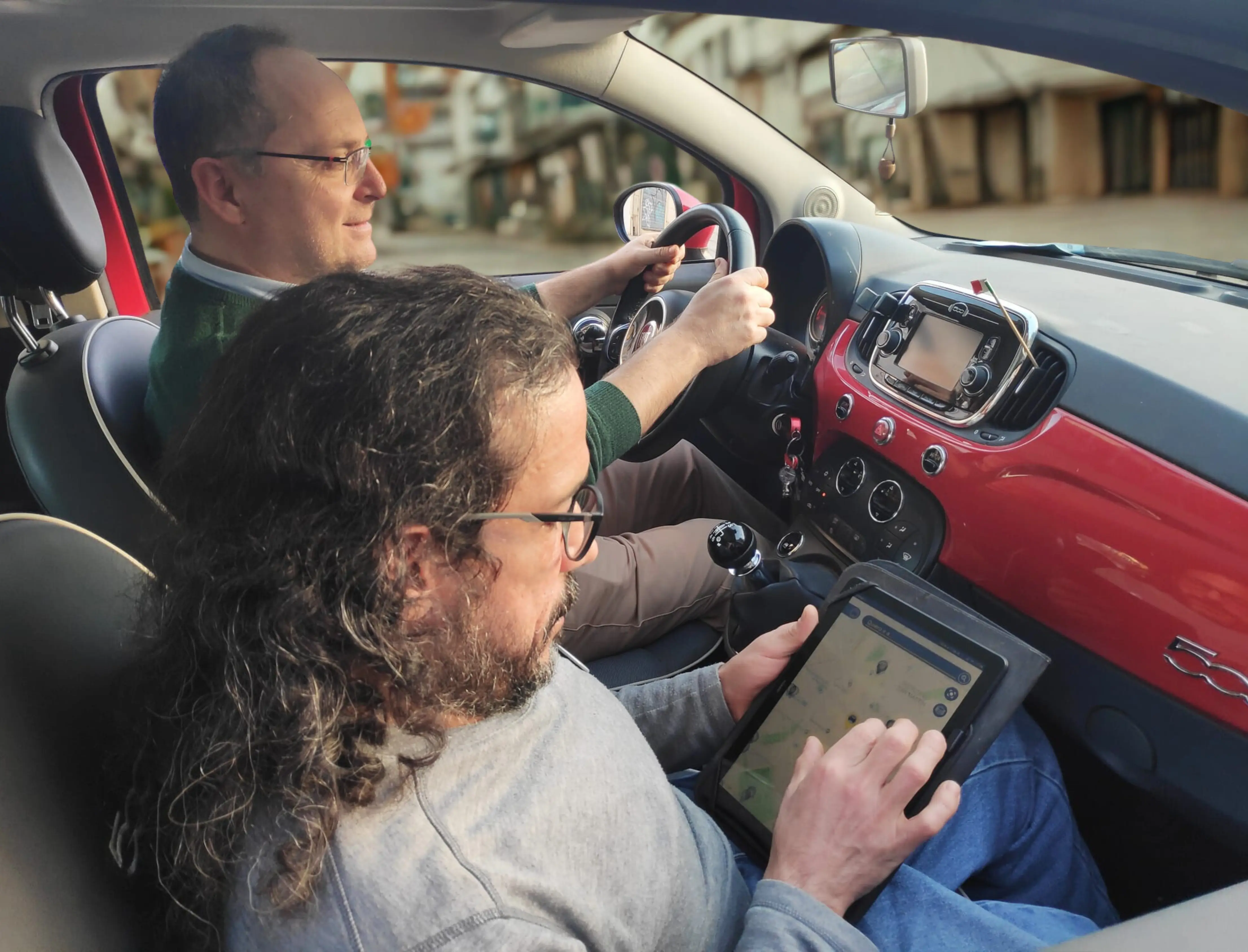 President Carlo demonstrating the functionality of the Park4Dis App to a companion inside a moving vehicle